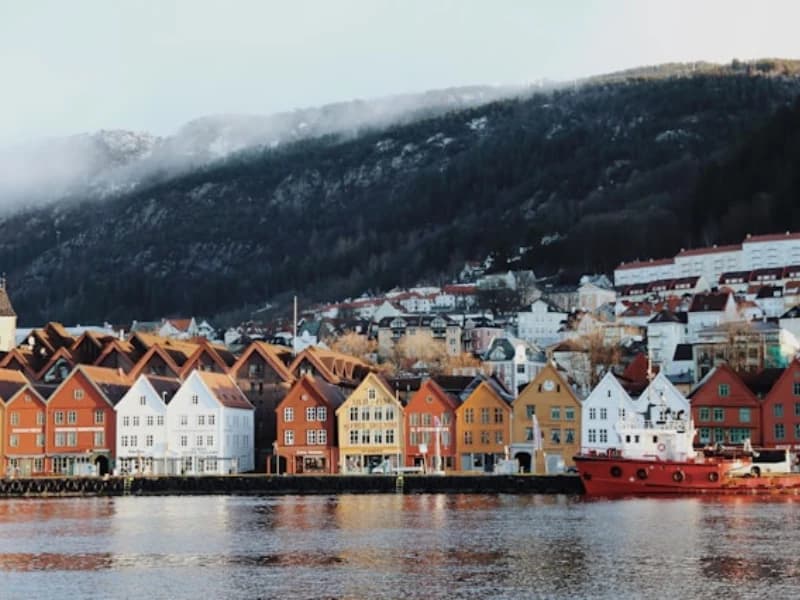 Colourful waterfront buildings in Bergen beneath a mountain